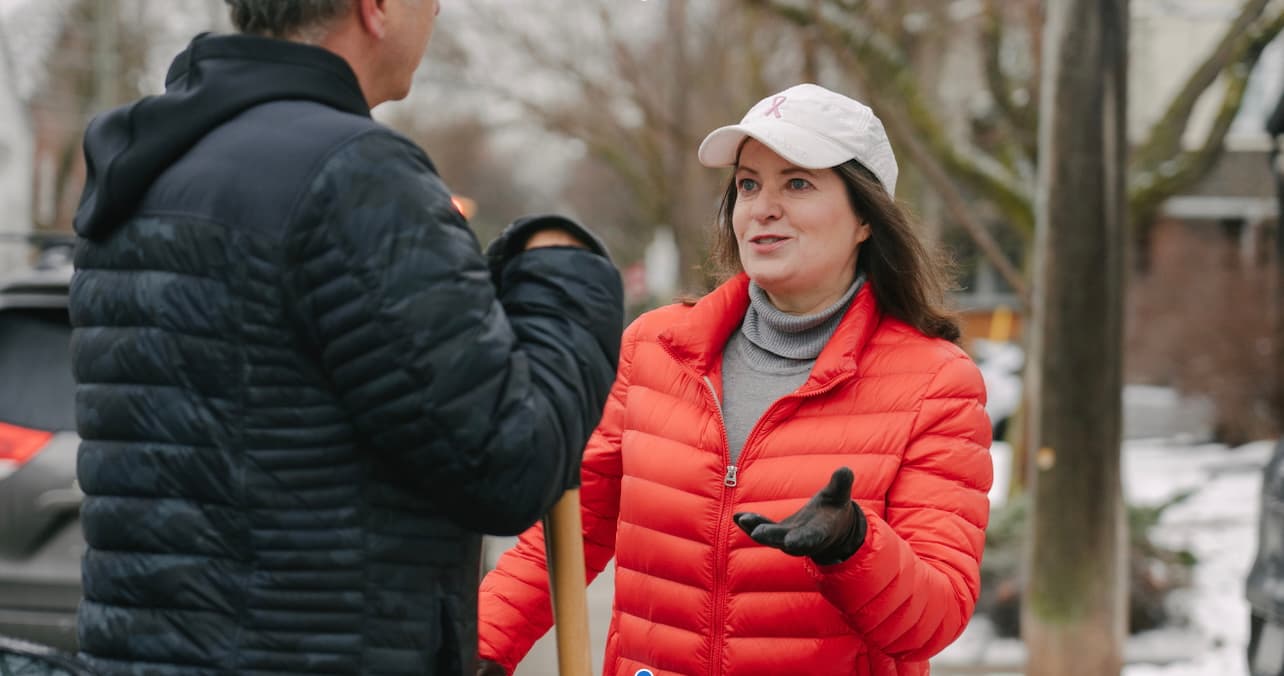 Stephanie Bowman discutant avec une résidente dans une rue en hiver